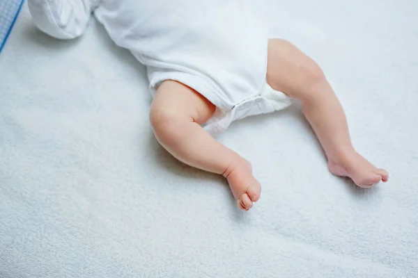 用尿布把新生婴儿的脚放在更衣室的桌子上 可爱的小女孩或男孩两个星期大 干性和健康的身体和皮肤概念 幼儿保育 — 图库照片