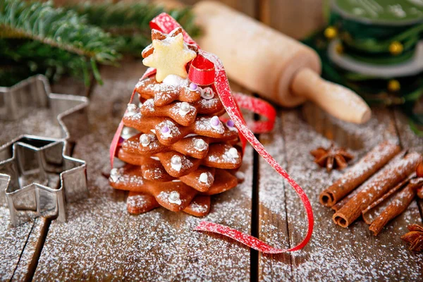 自制的圣诞姜饼树作为礼物送给有木制背景的家人和朋友 背景上有圣诞树的彩灯 圣诞节送糖衣礼物 — 图库照片