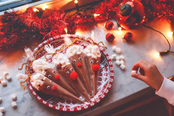 学龄前小女孩抱着用巧克力可可粉和棉花糖制成的驯鹿 圣诞期间儿童自制甜点饮料 — 图库照片