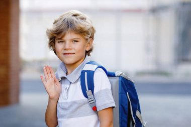 Sırt çantası ya da Almancası Ranzen olan küçük mutlu bir çocuk. Okul çocuğu okula gidiyormuş. Dışarıdaki sağlıklı sevimli çocuğun portresi. Öğrenci, öğrenci, okula dönün. İlkokul çağında..
