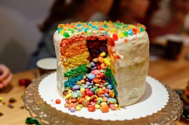 Closeup of homemade rainbow cake with chocolate lentils inside