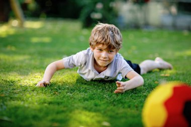 Aktif çocuk mutlu çocuk futbol topu Alman bayrağı renklerde oynamak. Sağlıklı çocuk futbol oyunu ve eylem açık havada ile eğleniyor.