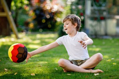 Aktif çocuk mutlu çocuk futbol topu Alman bayrağı renklerde oynamak. Sağlıklı çocuk futbol oyunu ve eylem açık havada ile eğleniyor.