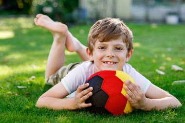 Aktif çocuk mutlu çocuk futbol topu Alman bayrağı renklerde oynamak. Sağlıklı çocuk futbol oyunu ve eylem açık havada ile eğleniyor.