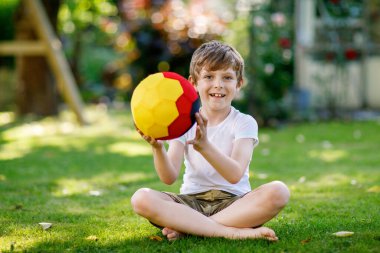 Aktif çocuk mutlu çocuk futbol topu Alman bayrağı renklerde oynamak. Sağlıklı çocuk futbol oyunu ve eylem açık havada ile eğleniyor.