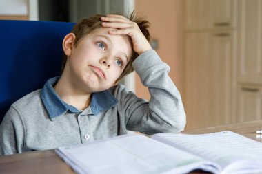 Corona salgınından dolayı karantina zamanında ödev yapan liseli çocuk. Ağlayan ve üzgün çocuk evde kalmak sinir bozucu.