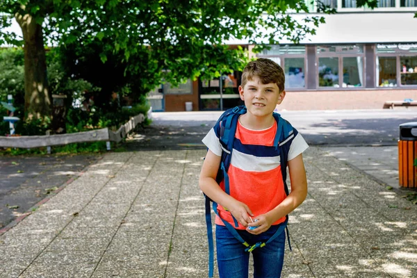 一个戴着医疗面具的小男孩在上学的路上 带背包的孩子 暑假后回到学校 日冕大流行期间的保护 在学校院子里和大楼里的健康孩子 — 图库照片