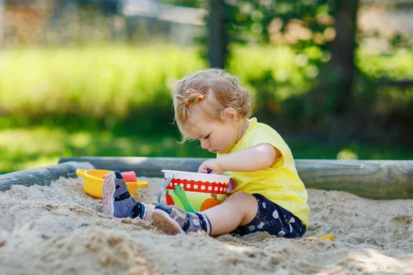 놀이터에서 속에서 화창하고 여름날 아기가 재미있게 장난감을 가지고 의상을 활동적 — 스톡 사진