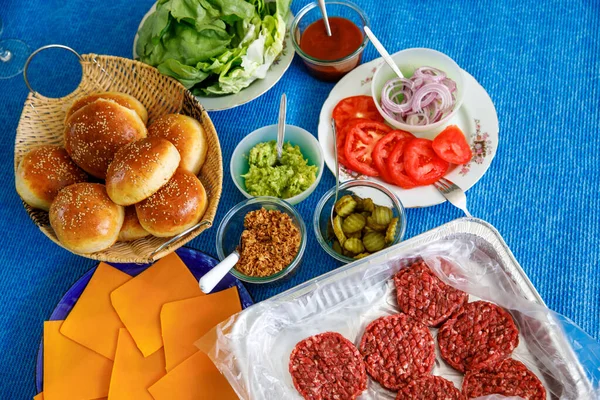 ファーストフード ハンバーガーパーティーのコンセプト フランスのフライドポテトとソースがセットされた様々なおいしいハンバーガー明るい青の背景にフラットレイトップビューコピースペース — ストック写真