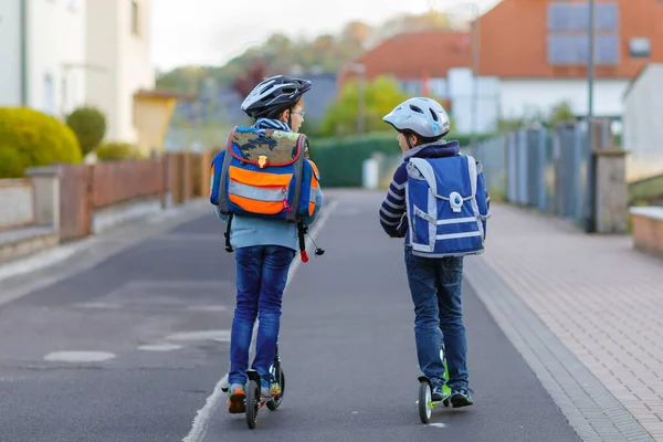 도시에서 헬멧을 스쿠터를 가방을 있습니다 자전거를 등교하는 어린이들 야외에서 등교하는 — 스톡 사진