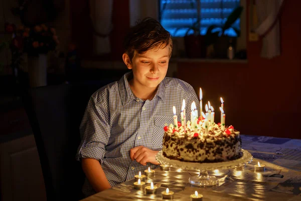 彼の誕生日を祝う幸せなブロンドの小さな男の子 自家製の焼き菓子 屋内でろうそくを吹く前に子供 学校の子供のための誕生日パーティー 家族のお祝い ティーンエイジャーの誕生日 — ストック写真