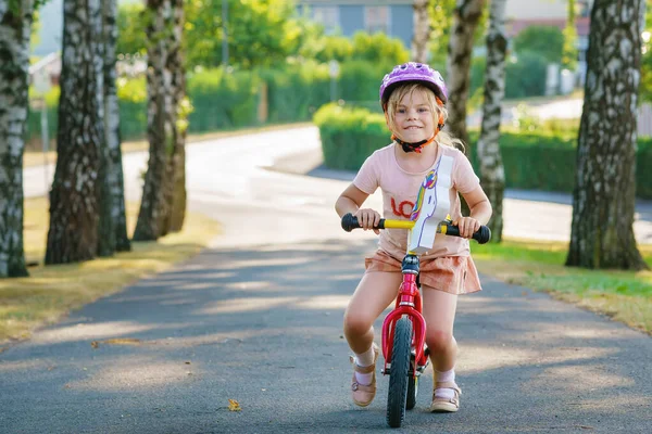 带着头盔的学龄前小女孩骑着平衡自行车跑步 快乐的孩子驾驶 骑自行车 户外活动 儿童暑期活动 — 图库照片