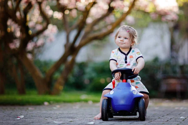 Χαριτωμένο Μικρό Κοριτσάκι Παίζει Μπλε Παιχνίδι Μικρό Αυτοκίνητο Στον Κήπο — Φωτογραφία Αρχείου