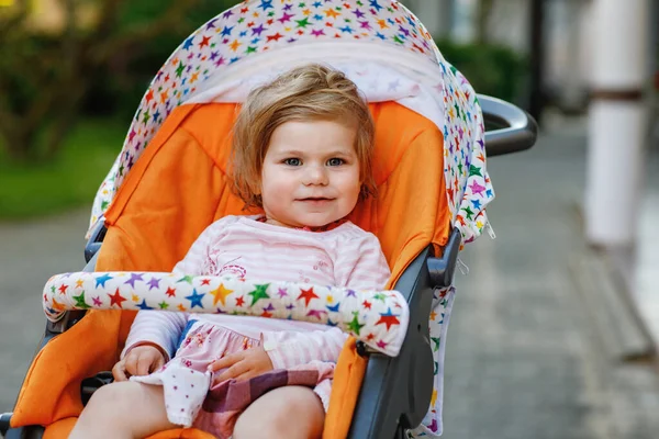 ベビーカーやプラムに座って散歩に行く小さなかわいい笑顔の幼児の少女の肖像画 屋外で楽しい時間を過ごしている幸せなかわいい赤ちゃん 健康な娘 — ストック写真