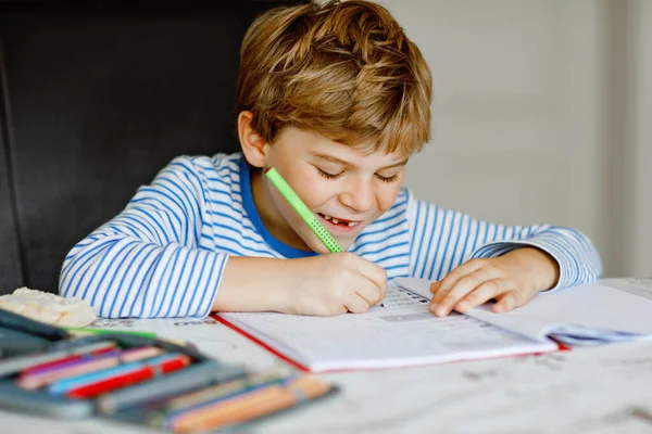 可爱健康快乐的学童在家里做作业的肖像 小孩子在屋里用彩色铅笔写字小学和教育 孩子们学习书写字母和数字 — 图库照片