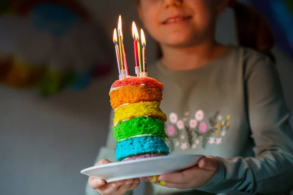 快乐的学龄前小女孩庆祝生日 带着自制彩虹蛋糕的儿童服装 快乐健康的幼儿在蛋糕上吹着6支蜡烛 有选择地关注蛋糕 — 图库照片