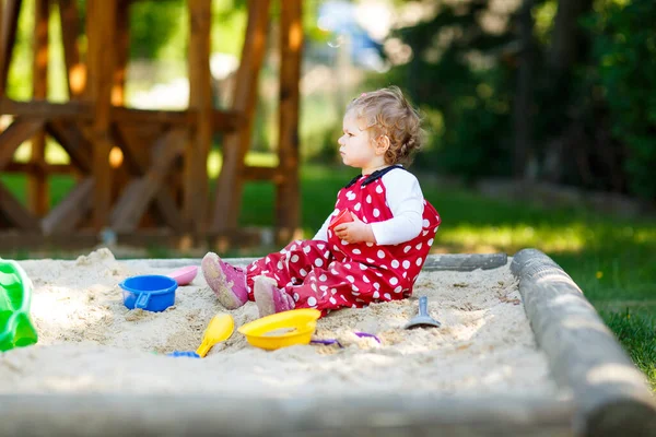 Симпатичная Малышка Играет Песке Открытой Площадке Ребенок Красных Брюках Веселится — стоковое фото