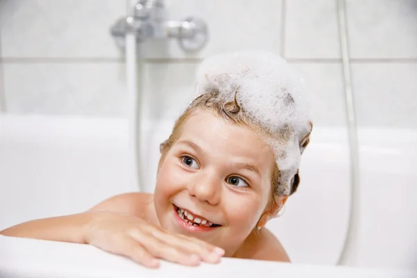 シャンプーフォームと泡が髪を入浴でかわいい子 幸せな笑顔の就学前の女の子の健康管理と衛生の概念の肖像 髪を一人で洗う — ストック写真