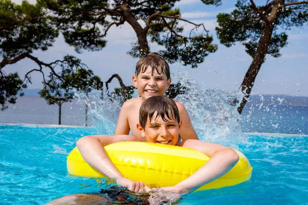 Dva Kluci Baví Nafukovacích Gumových Kroužcích Venkovním Bazénu Letní Prázdniny — Stock fotografie