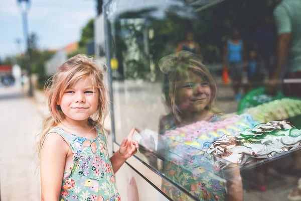 屋外のスタンドカフェでアイスクリームを選んで購入する幸せな就学前の女の子 かわいい子供のアイスクリームのさまざまな種類を見て 家族の休暇で甘い夏のデザート — ストック写真