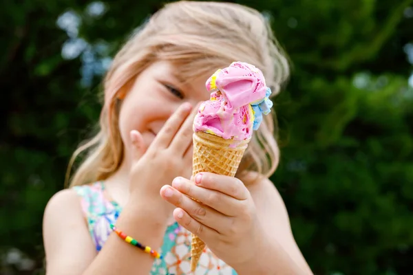 阳光明媚的夏日 学龄前小女孩在华夫饼筒里吃着五彩缤纷的冰淇淋 快乐极了 小孩子吃冰淇淋甜食 炎热温暖的夏天吃甜食 明亮的灯光 五彩缤纷的冰淇淋 — 图库照片