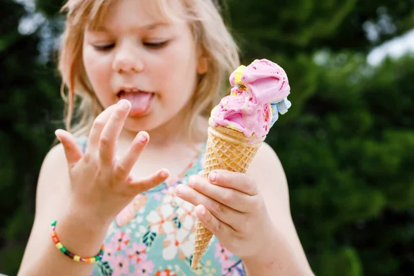 阳光明媚的夏日 学龄前小女孩在华夫饼筒里吃着五彩缤纷的冰淇淋 快乐极了 小孩子吃冰淇淋甜食 炎热温暖的夏天吃甜食 明亮的灯光 五彩缤纷的冰淇淋 — 图库照片