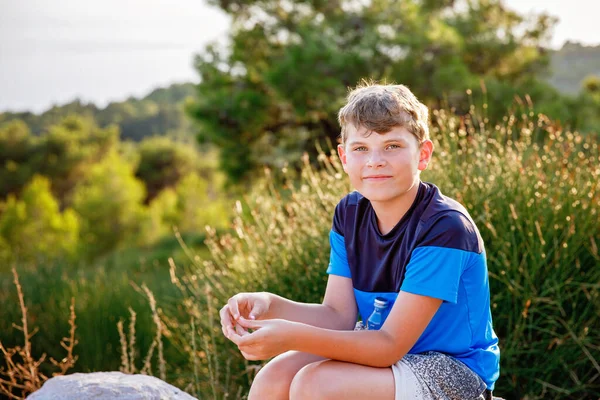 Σχολείο Αγόρι Κάθεται Στο Λόφο Στο Γρασίδι Τομέα Και Απολαμβάνοντας — Φωτογραφία Αρχείου