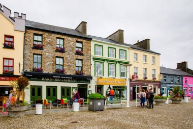 CLIFDEN, IRELAND - 16 July, 2019: Awesome and colorful streets of Clifden, Connemara, Ireland. Colourful houses, doors, pubs, windows with flowers clipart