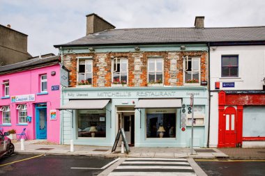 Clifden, Connemara, İrlanda 'nın muhteşem ve renkli caddeleri 16 Temmuz 2019. Renkli evler, kapılar, barlar, çiçekli pencereler