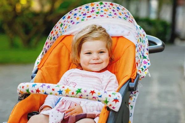 ベビーカーやプラムに座って散歩に行く小さなかわいい笑顔の幼児の少女の肖像画 屋外で楽しい時間を過ごしている幸せなかわいい赤ちゃん 健康な娘 — ストック写真
