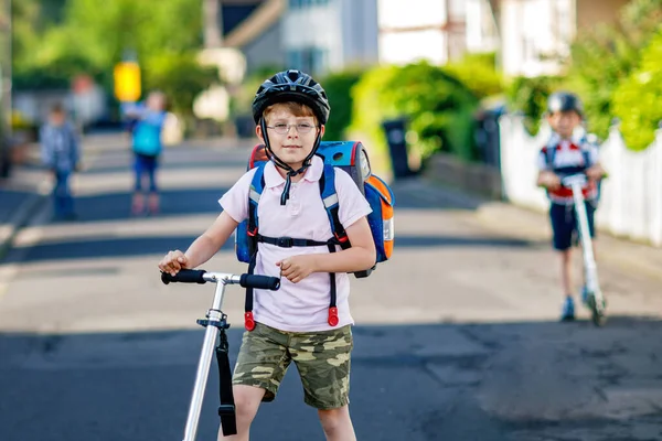 Dwóch Chłopców Kasku Jeździ Hulajnogą Mieście Plecakiem Słoneczny Dzień Szczęśliwe — Zdjęcie stockowe