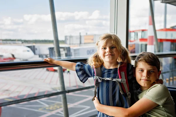 Κοριτσάκι Και Σχολιαρόπαιδο Στο Αεροδρόμιο Περιμένουν Επιβίβαση Στο Μεγάλο Παράθυρο — Φωτογραφία Αρχείου