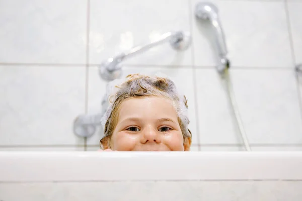可爱的孩子与洗发水泡沫和泡沫的头发洗澡 快乐微笑的幼儿女童保健与卫生观念的写照 自己洗头 — 图库照片