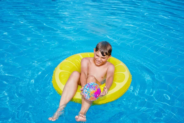 清凉的学童在室外游泳池的充气橡皮圈里玩得很开心 夏天的孩子周末 在游泳池里的孩子家庭度假时在水上公园打圈的小男孩真有趣 — 图库照片