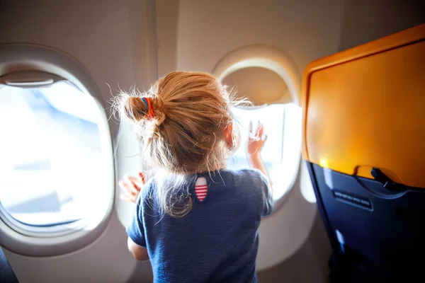 可爱的小女孩坐飞机旅行 小孩坐在飞机窗前 看着外面 和孩子们一起出国旅行暑假的家庭 — 图库照片