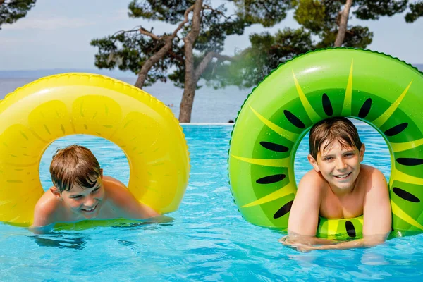 Два Мальчика Веселятся Надувных Резиновых Кольцах Открытом Бассейне Летние Каникулы — стоковое фото