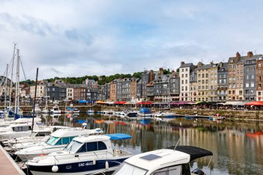 HONFLEUR, FRANCE - 23 Ağustos 2022: Honfleur 'un pitoresk limanı, yatlar ve eski evler suya yansıdı.