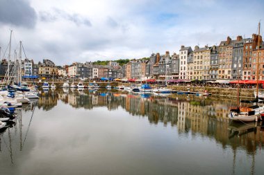 HONFLEUR, FRANCE - 23 Ağustos 2022: Honfleur 'un pitoresk limanı, yatlar ve eski evler suya yansıdı.