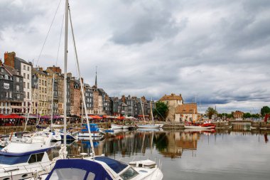 HONFLEUR, FRANCE - 23 Ağustos 2022: Honfleur 'un pitoresk limanı, yatlar ve eski evler suya yansıdı.