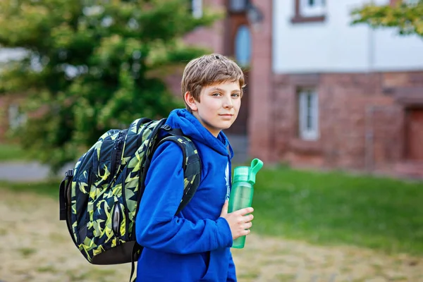 快乐的十几岁前的男孩 背着背包 背包和水瓶 在温暖的阳光明媚的夏天 小学生在去小学或中学的路上 城市里大街上的健康儿童 — 图库照片