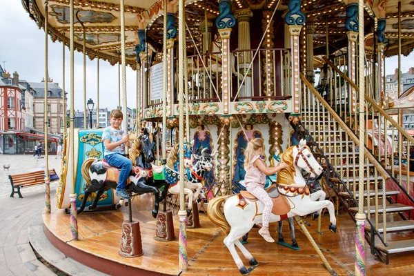 可敬的小女孩和小学生 乘坐着古老的旋转木马在法国的洪福勒市兜风 弟妹们 弟妹们玩得开心 — 图库照片