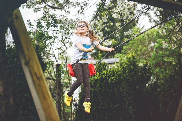 Menina Pré Escolar Pequena Feliz Com Óculos Divertindo Balanço Jardim — Fotografia de Stock