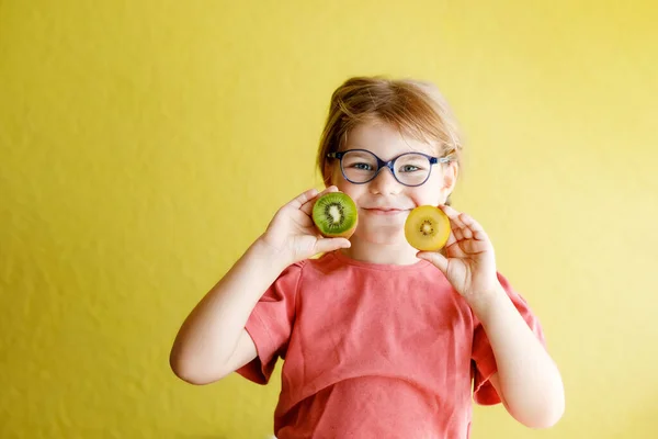 Happy Little Child Girl Yellow Green Kiwi Fruits Yellow Background — Zdjęcie stockowe