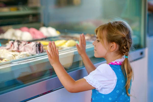 屋外のスタンドカフェでアイスクリームを選んで購入するかわいい就学前の女の子 さまざまな種類のアイスクリームを見ている幸せな笑顔の子供 甘い夏のデザート — ストック写真