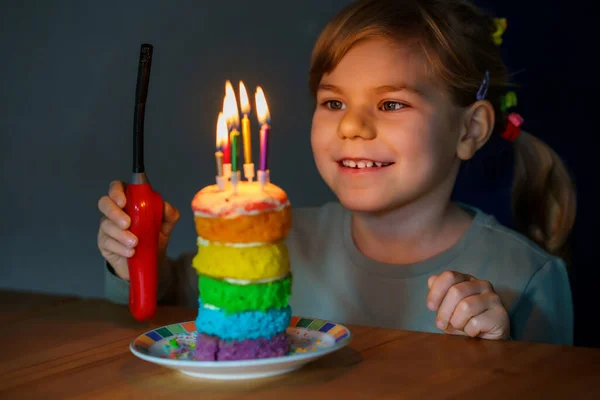 快乐的学龄前小女孩庆祝生日 带着自制彩虹蛋糕的儿童服装 快乐健康的幼儿在蛋糕上吹着6支蜡烛 有选择地关注蛋糕 — 图库照片