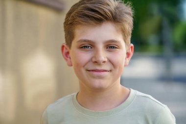 Yakışıklı liseli çocuğun portresi. Güzel mutlu çocuk kameraya bakıyor. Okullu çocuk gülümsüyor. Eğitim konsepti. Gençler açık havada.