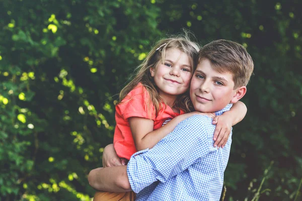 Happy Little Girl Embraces Her Loving Brother Teenager Boy Showcasing — Stock Photo, Image
