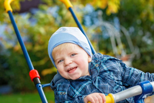 可爱的小男孩在户外玩三轮车 孩子们在秋天的公园里玩得开心 蹒跚学步的小男孩穿着时髦的夹克 微笑的金发男孩肖像画 秋天的时尚 外面是时髦的孩子 — 图库照片