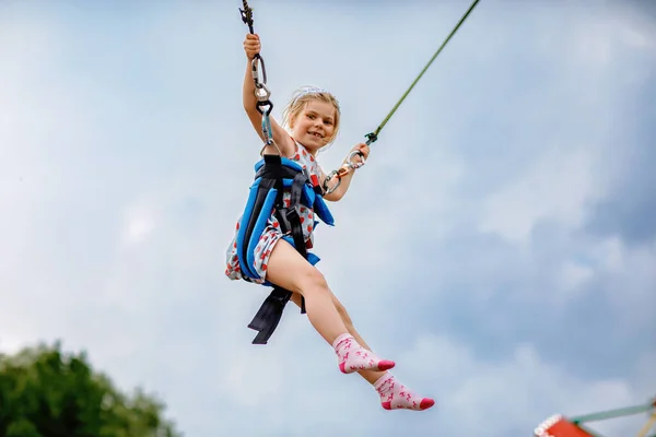 トランポリンジャンプロープでジャンプを楽しむ小さな就学前の女の子 遊園地で幸せな子供 家族活動 — ストック写真