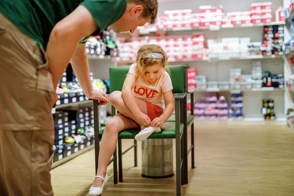 小さな女の子とお父さんお店で靴を買う 子供と男は慎重に一緒に完璧なペアを選択します 大切に思い出を作成し 家族としての関係を強化 — ストック写真